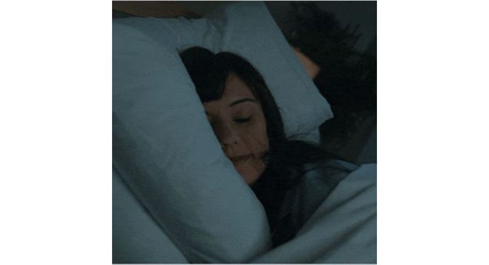 A model sleeping in bed.