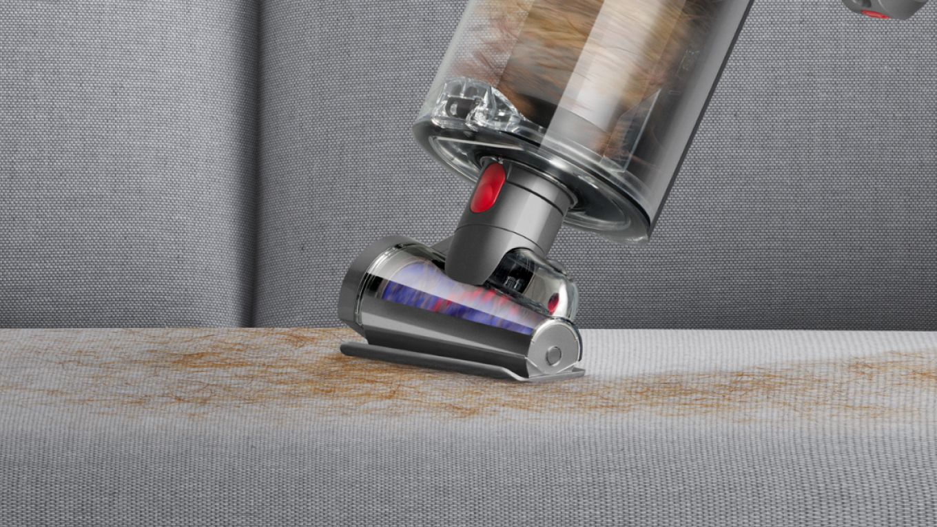 Close-up of the Hair screw tool removing pet hair from a sofa.