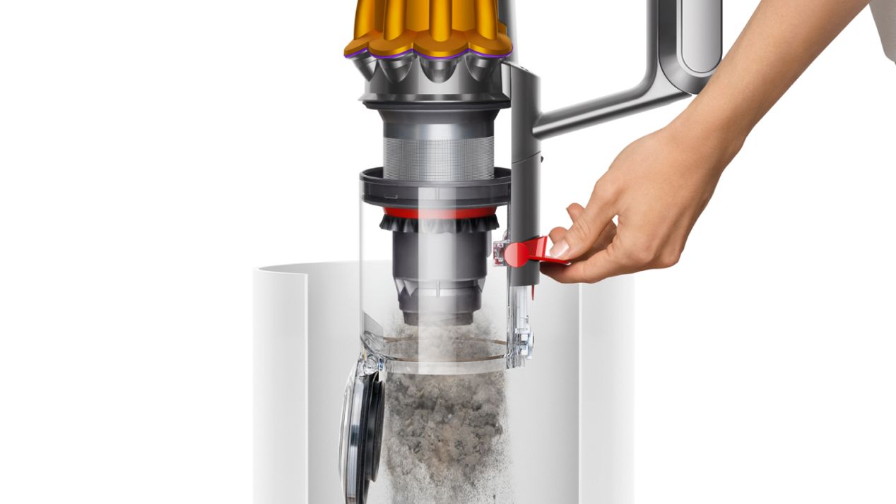 A person empties the bin of the Dyson V12s Detect Slim Submarine Complete floor-mopping vacuum cleaner.