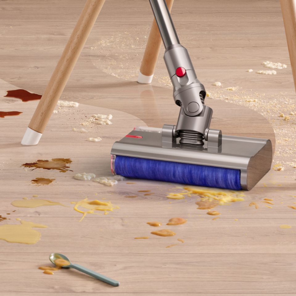 The Dyson V12s Detect Slim Submarine Complete vacuum cleaner cleaning a dining room floor.