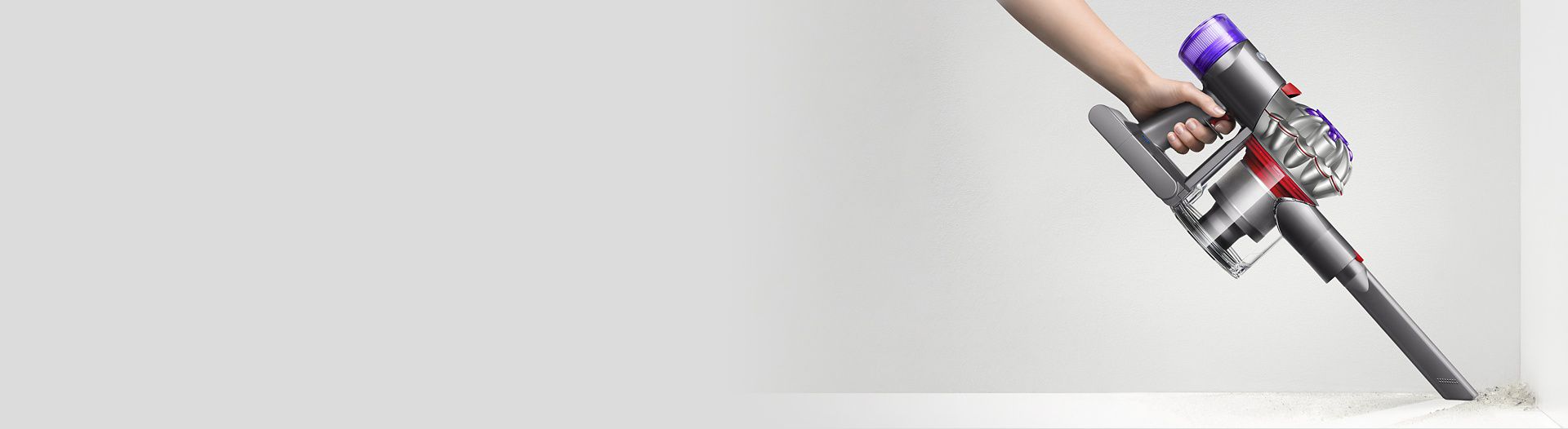 Side view of the Dyson V87 vacuum in handheld mode cleaning a corner.