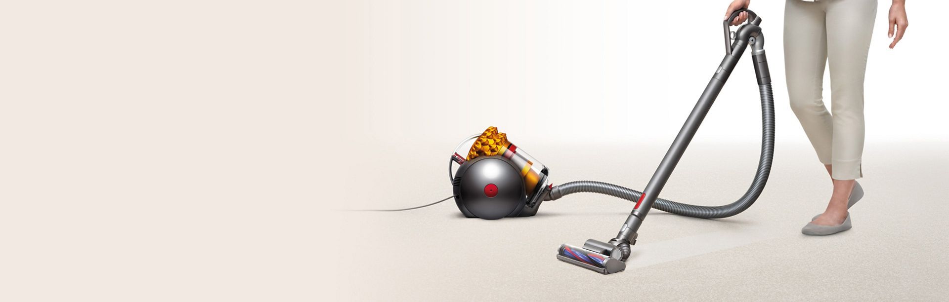 A woman cleans their home with a Dyson Big Ball Turbinehead vacuum cleaner.