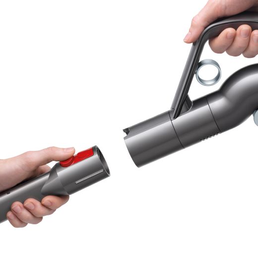 A person removing their vacuum cleaner attachment with a single click. A person removing their vacuum cleaner attachment with a single click.