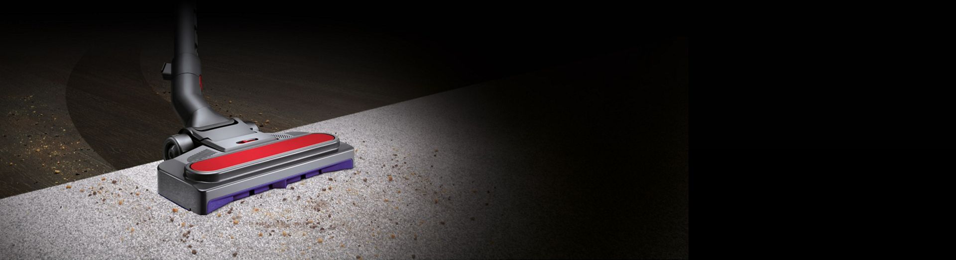 Close-up of the Pneumatic cleaner head vacuuming hard floor and carpet.