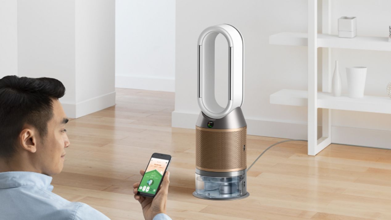 A man controls his Dyson air purifier using his smartphone. A man controls his Dyson air purifier using his smartphone.