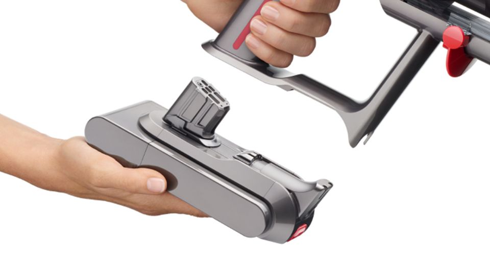 Nahaufnahme einer Hand, die einen Click-in-Akku am Dyson V15 Detect Staubsauger anbringt.
