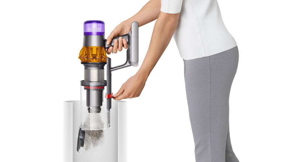 Eine Frau leert den Behälter des Dyson V15 Detect Staubsaugers.