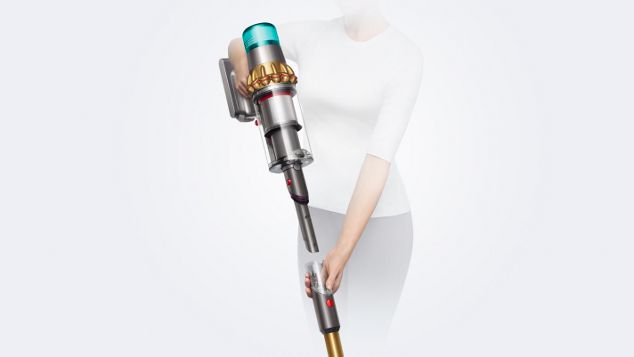 Una donna rimuove il tubo dell’aspirapolvere Dyson V15 Detect per rivelare la bocchetta a lancia integrata.