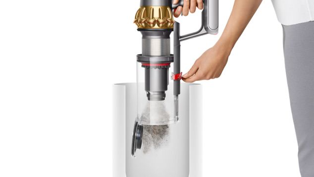 Una donna che svuota il contenitore dell’aspirapolvere Dyson V15 Detect.