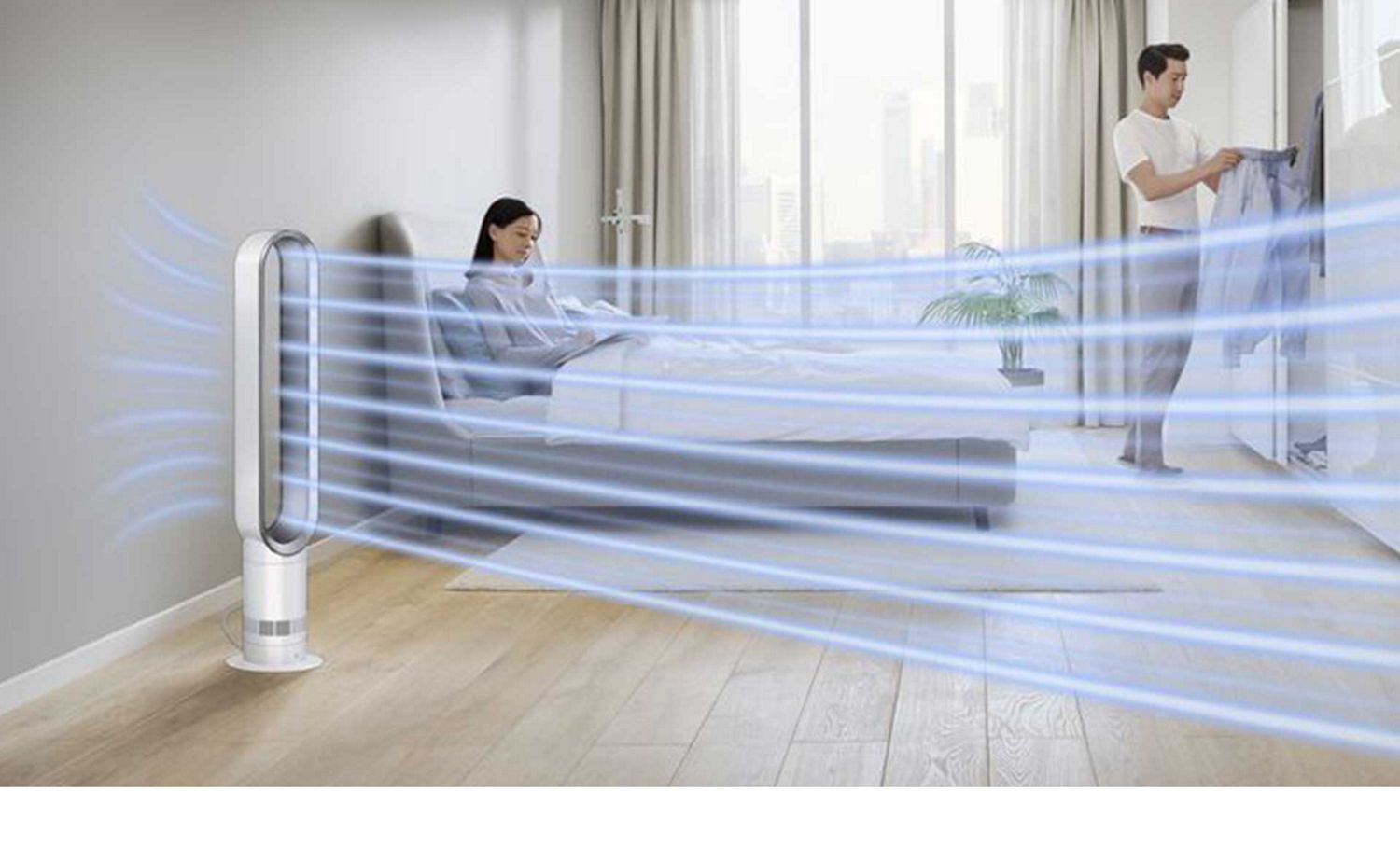 Dyson Cool tower fan circulates air throughout a bedroom to cool a couple.