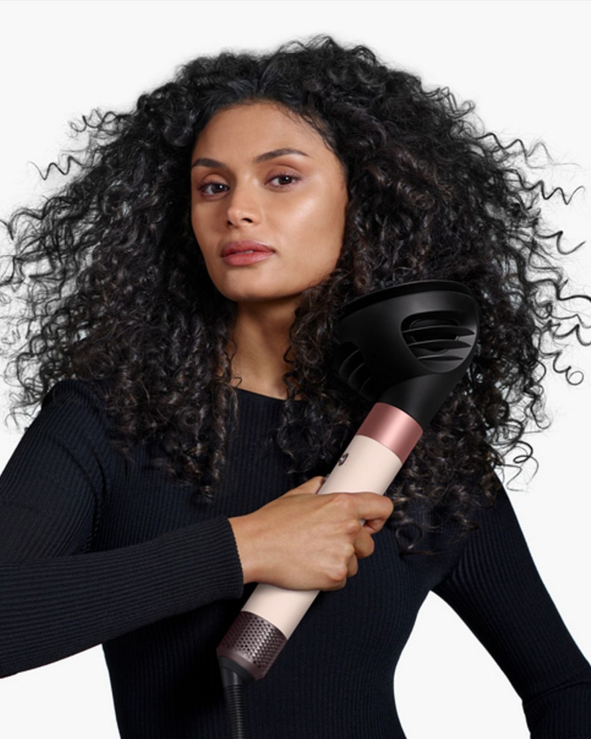 Model holding the Dyson Airwrap ID multi-styler and dryer with the Diffuser.
