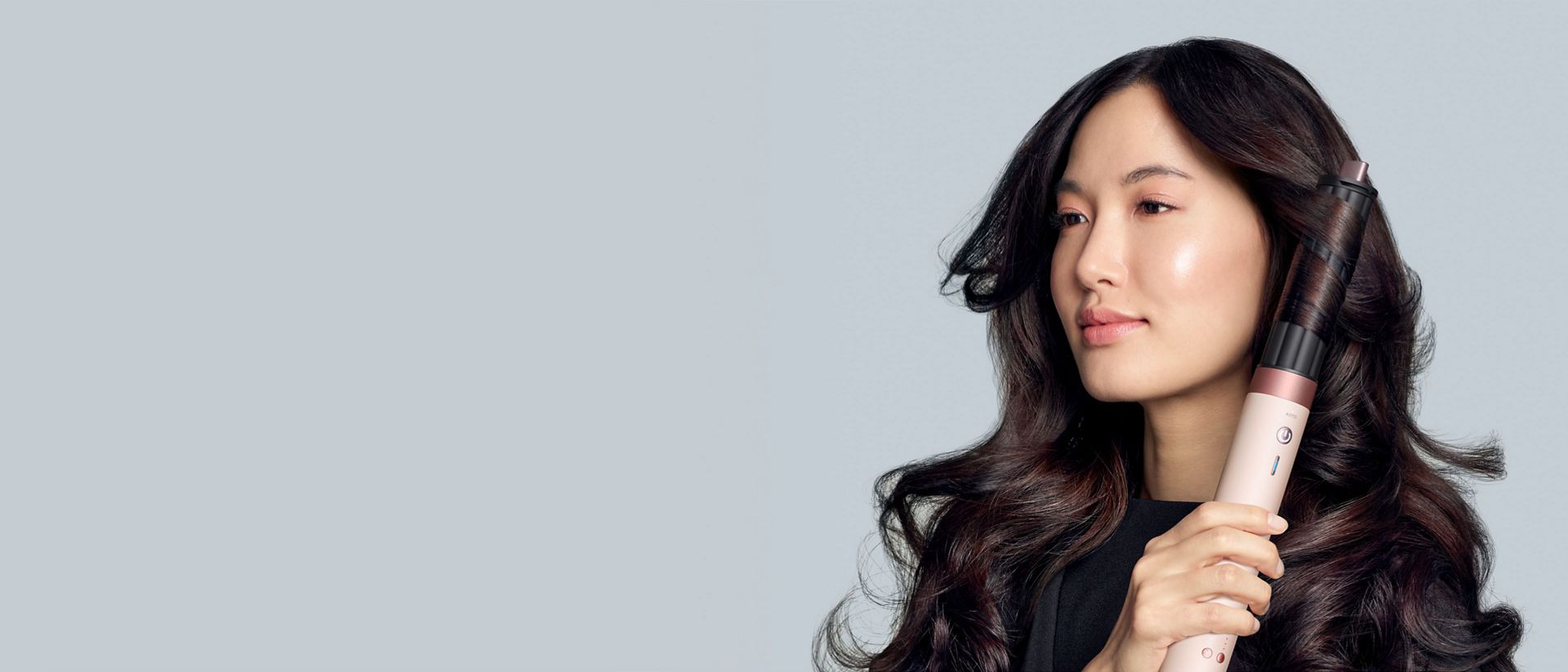 A model diffuses her coily hair using the Dyson Airwrap Co-anda2x multi-styler and dryer.