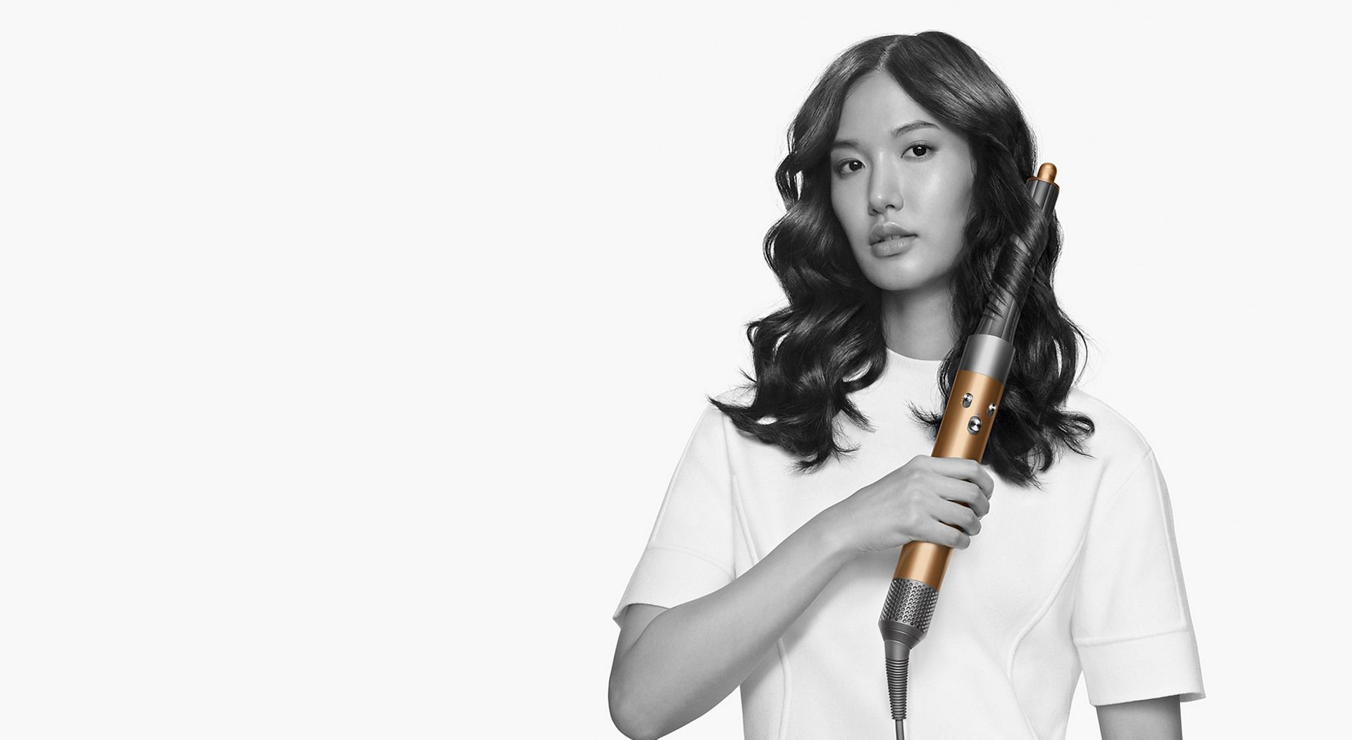 Model styling hair with The Dyson Airwrap multi-styler.