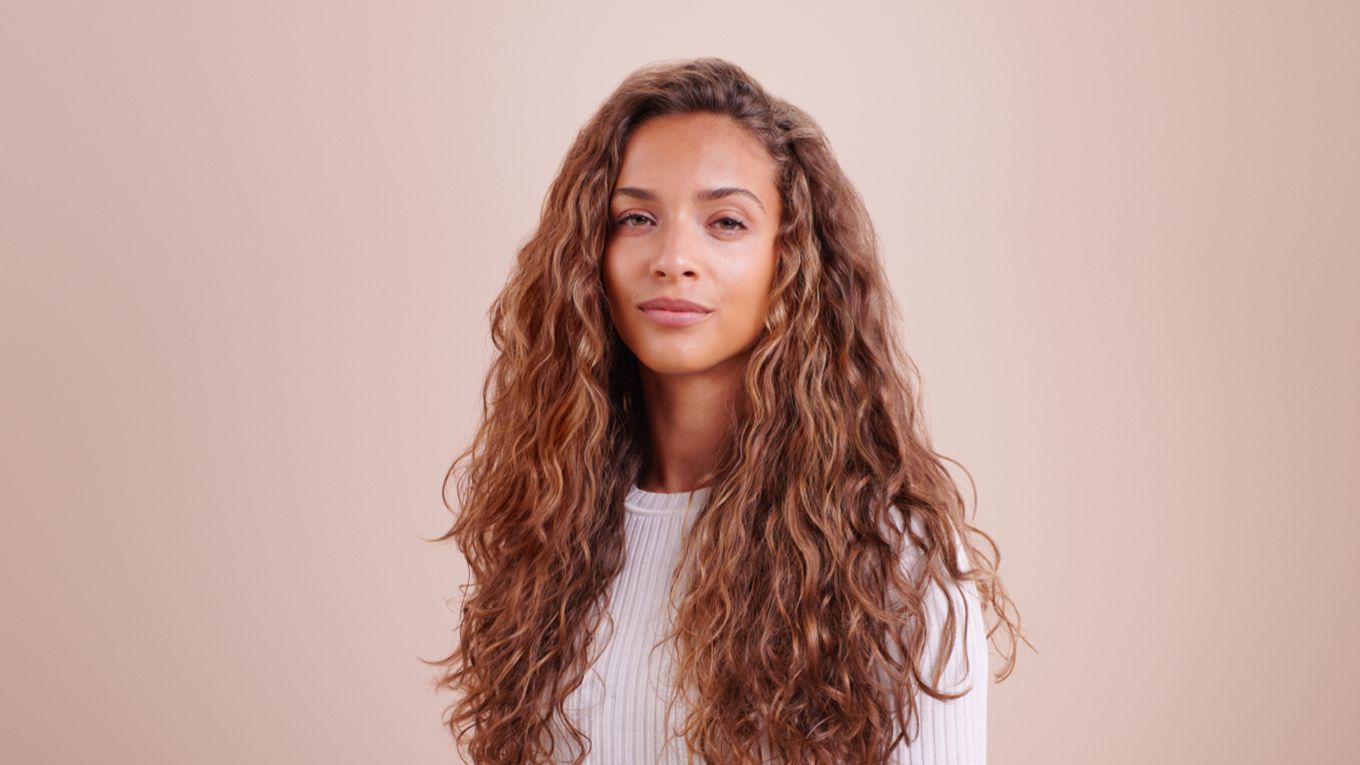 A model with styled wavy/curly hair Model wearing loose mermaid waves.