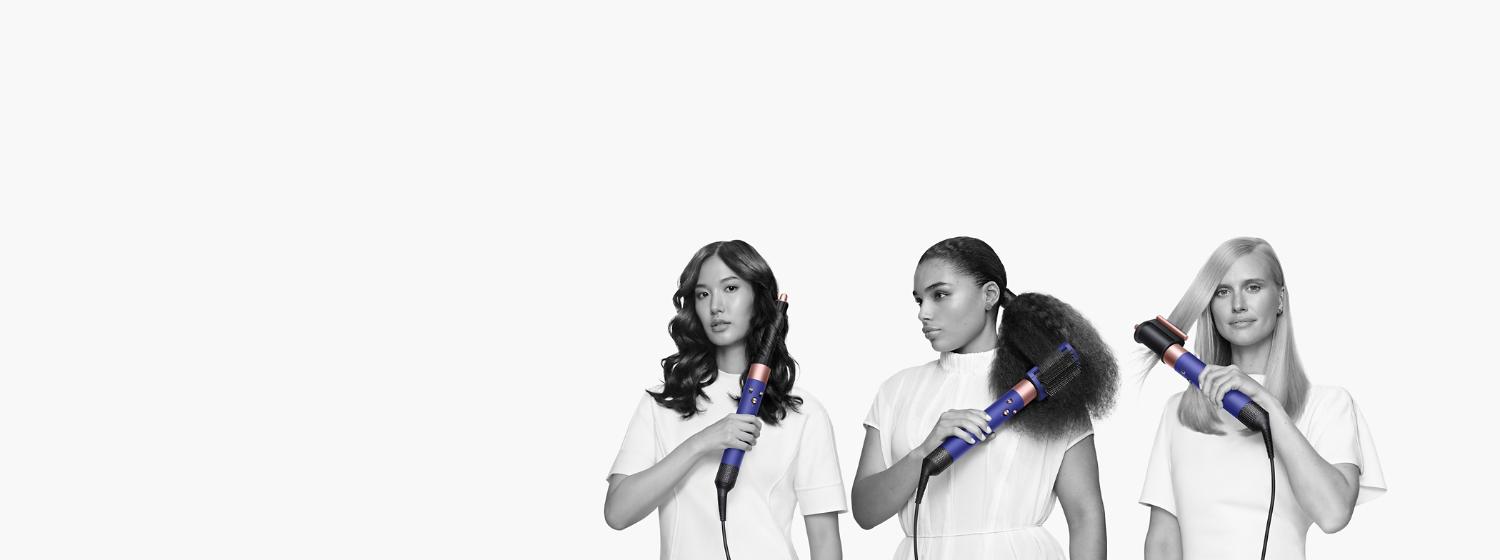 Trois mannequins se coiffant à l’aide du multistyler Dyson Airwrap muni de différents embouts. Trois mannequins se coiffant à l’aide du multistyler Dyson Airwrap muni de différents embouts.on Airwrap multi-styler and different attachments.