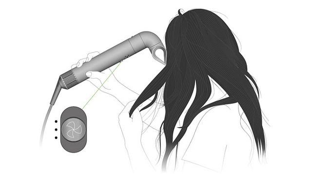 A model styling their hair using the Dyson Airwrap multi-styler and dryer and blade concentrator. The controls on the machine are highlighted.