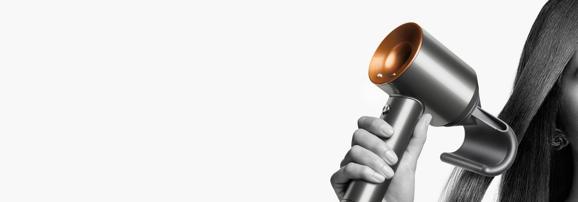 The Dyson Supersonic hair dryer with the Flyaway attachment held by a model.