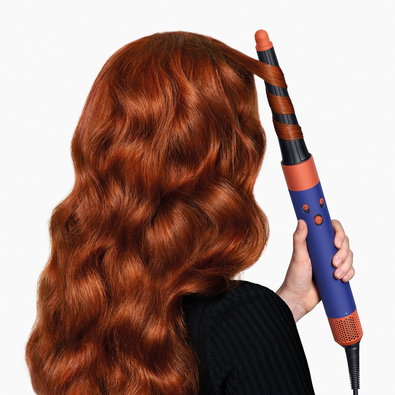 A model uses the Dyson Airwrap ID multi-styler and dryer to curl her hair.