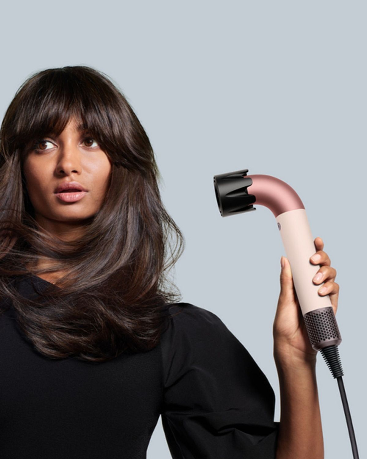 The Dyson Supersonic r is held by a model.