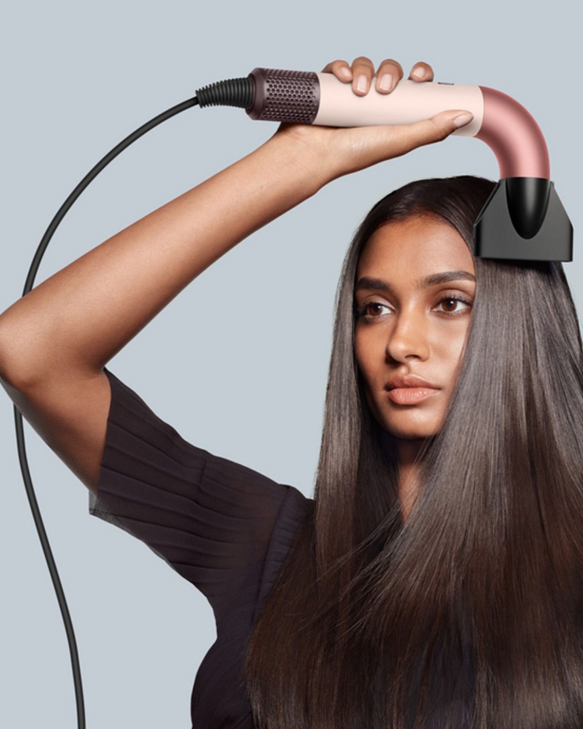 Model drying hair with the Dyson Supersonic r hair dryer and Pro concentrator attachment.