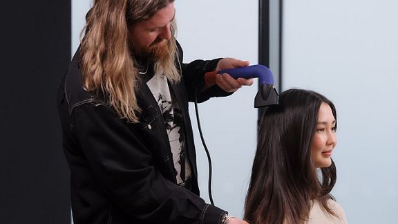 Global Styling Ambassador dries model's hair with Dyson Supersonic r Professional hair dryer with Intelligent attachment.