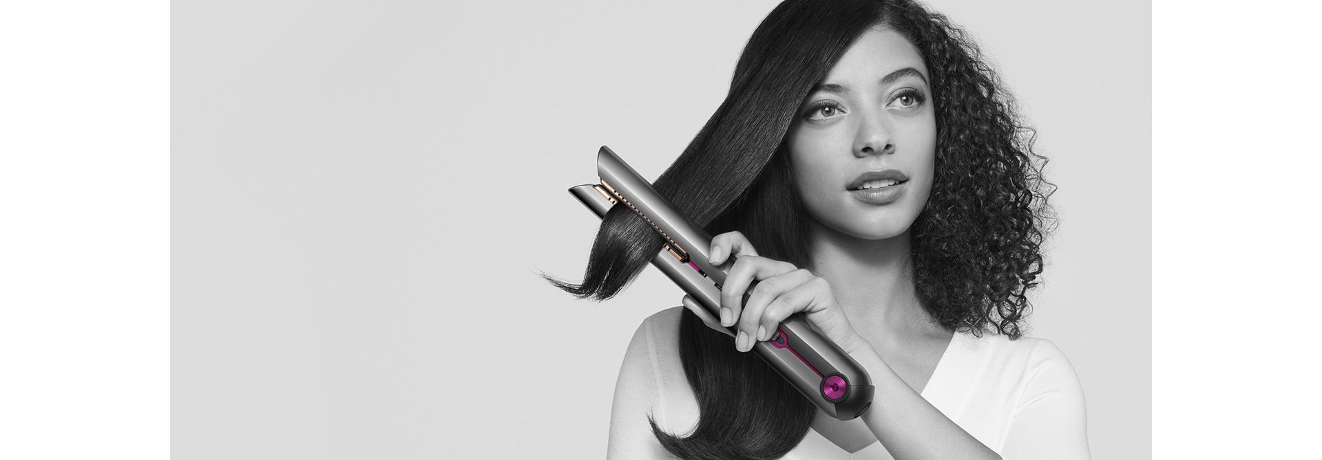 Frau glättet ihr Haar mit dem Dyson Corrale Haarglätter