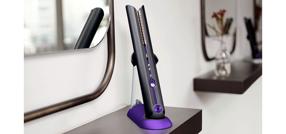Nahaufnahme des professionellen Stylisten mit einem kabellosen Dyson Corrale Glätteisen 