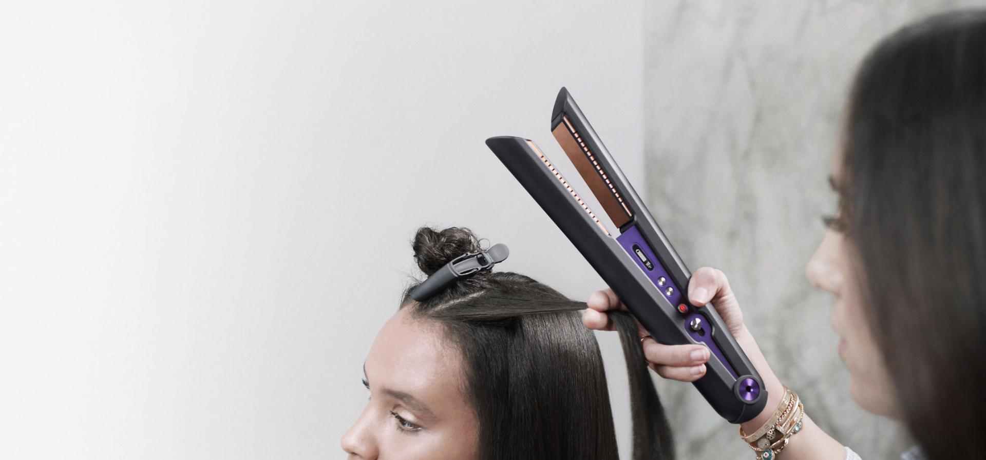 Close up of professional stylist using the Dyson Corrale hair straightener