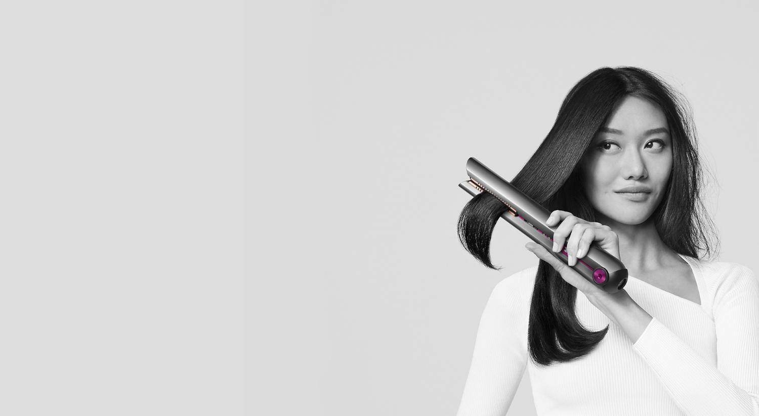 Woman styling hair with a Dyson Corrale straightener