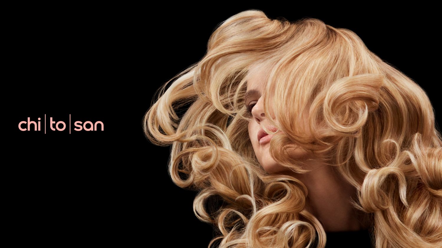 A blonde model with voluminous wavy hair styled with Dyson Chitosan.