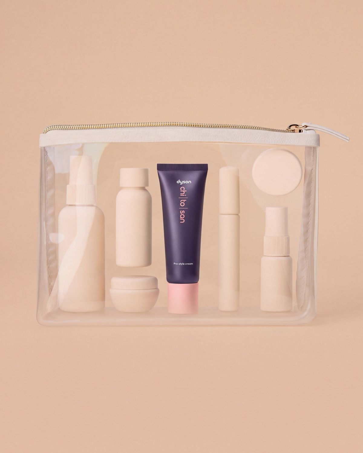 Dyson Chitosan Pre-style cream mini 30ml with other toiletries in a clear travel bag.