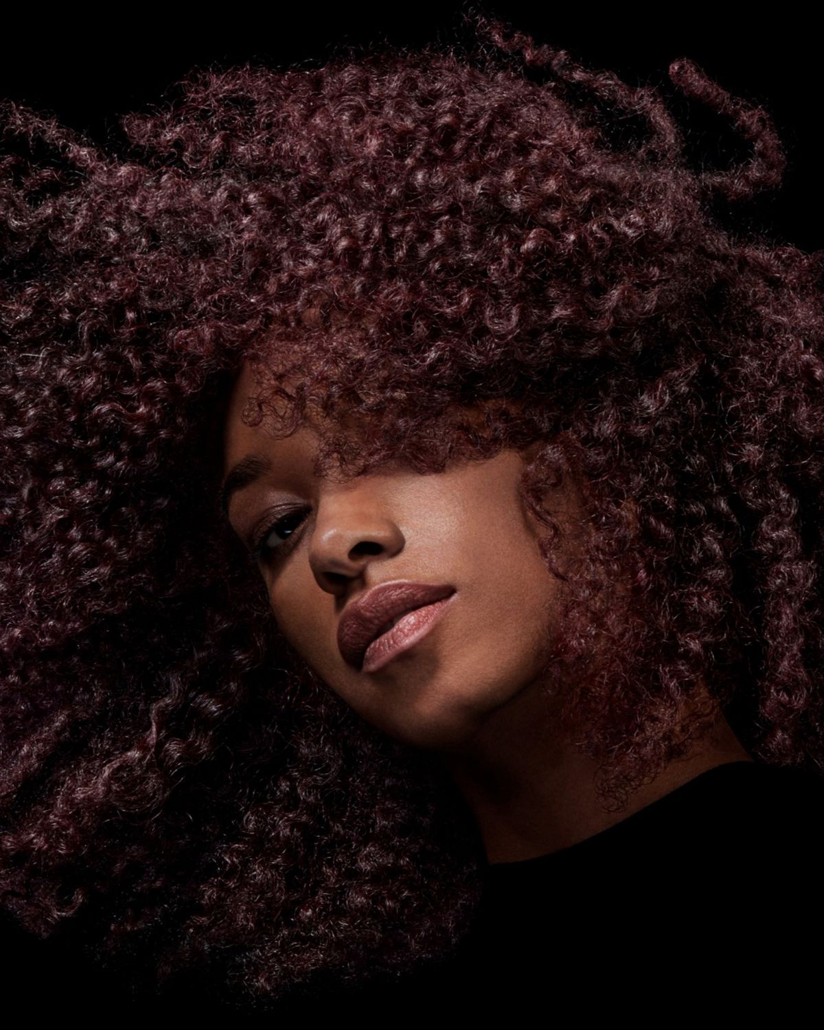 A model with black hair after styling their hair with Dyson Chitosan Pre-style cream.