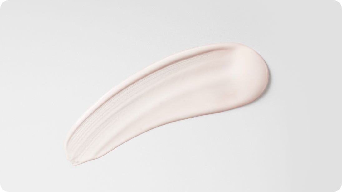 Sérum après-coiffage étalé sur fond blanc, montrant la texture.