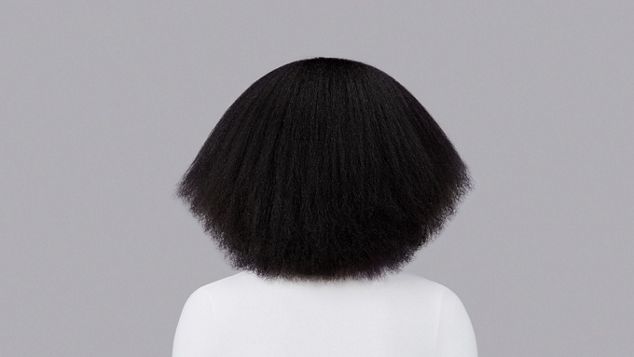 Naturlig krusete, mørkebrunt hår stylet med Dyson Chitosan Post-style-serum og Dyson Supersonic Nural. Sett bakfra.