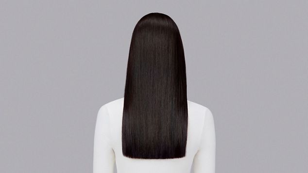 Naturlig rett, mørkt hår rettet med Dyson Chitosan Post-style-serum og Dyson Airstrait. Sett bakfra.