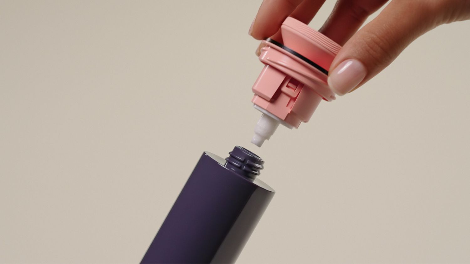 A model applies Dyson Chitosan Post-style serum to her hair.