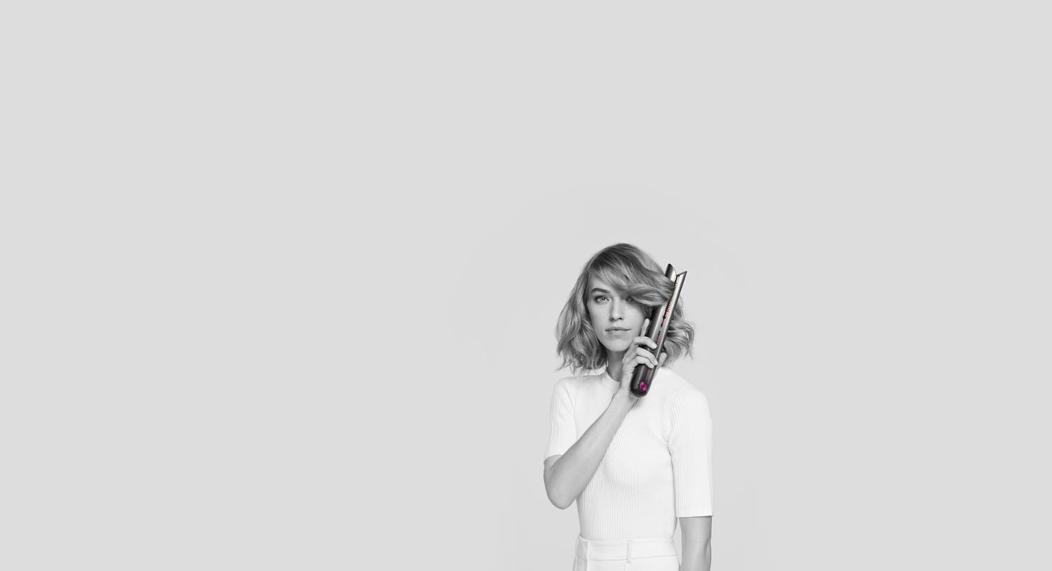 A woman using the Dyson Corrale to create waves.