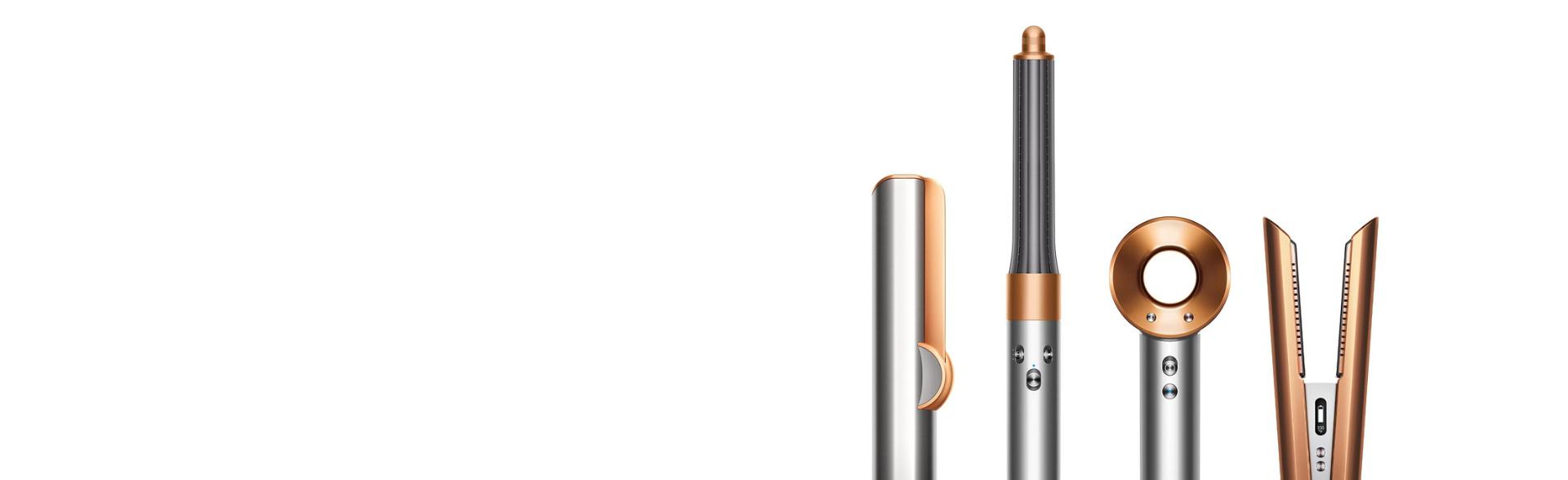 A line-up of Dyson hair care machines, in copper and nickel.