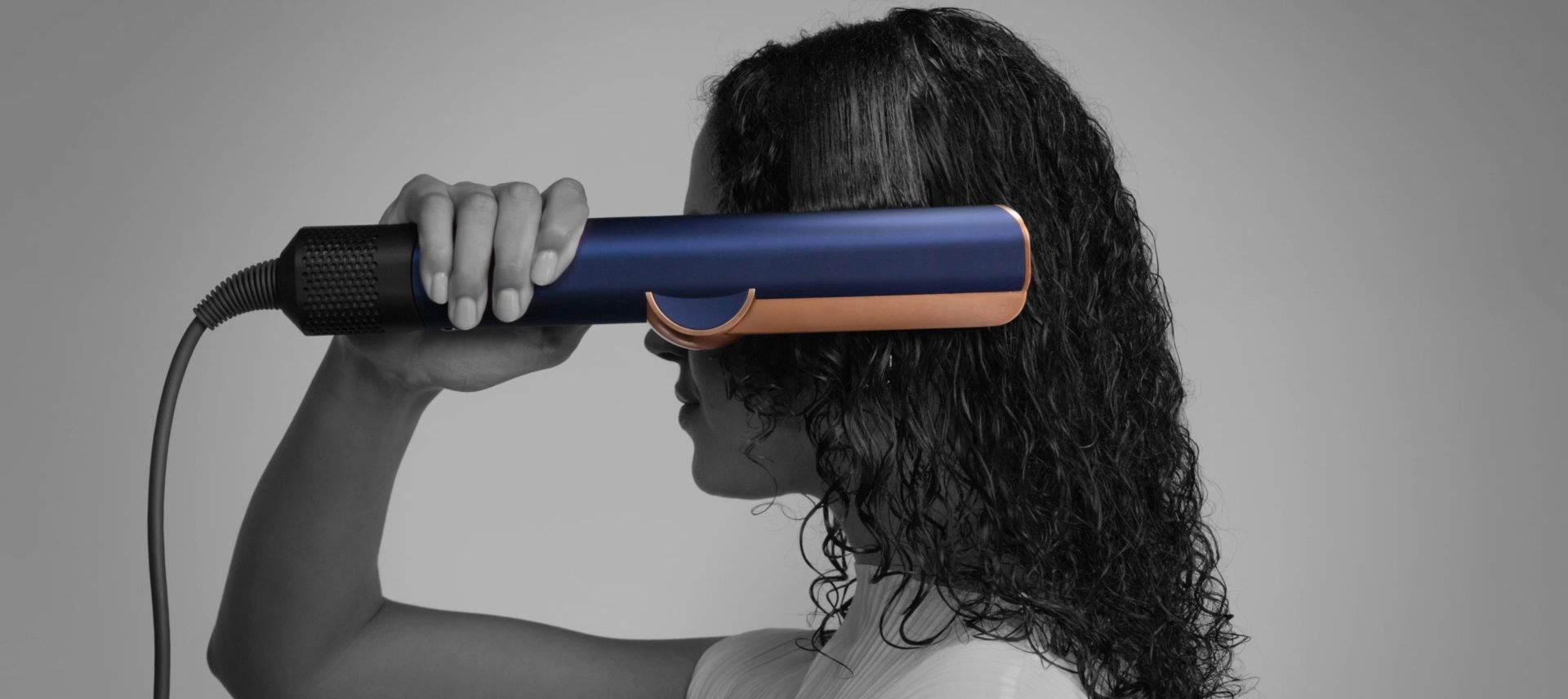 Dyson Airstrait straightener drying and straightening a tress of hair.