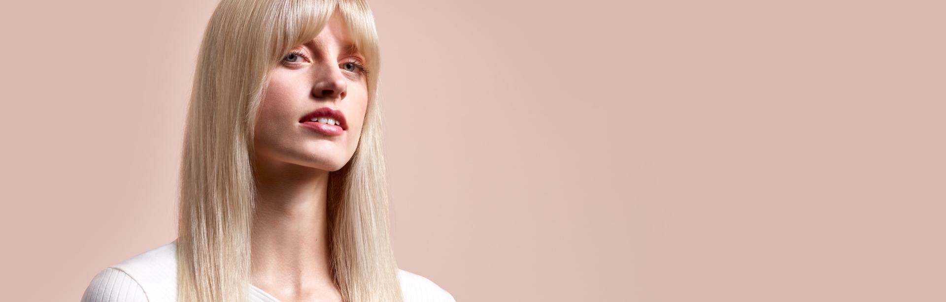 Una modelo con el cabello rubio, largoluciendo cabello lacio natural