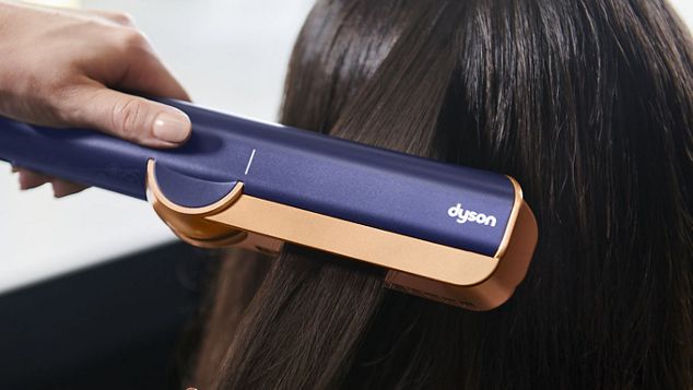 Close-up of model using the Dyson Airstrait on a tress of hair.