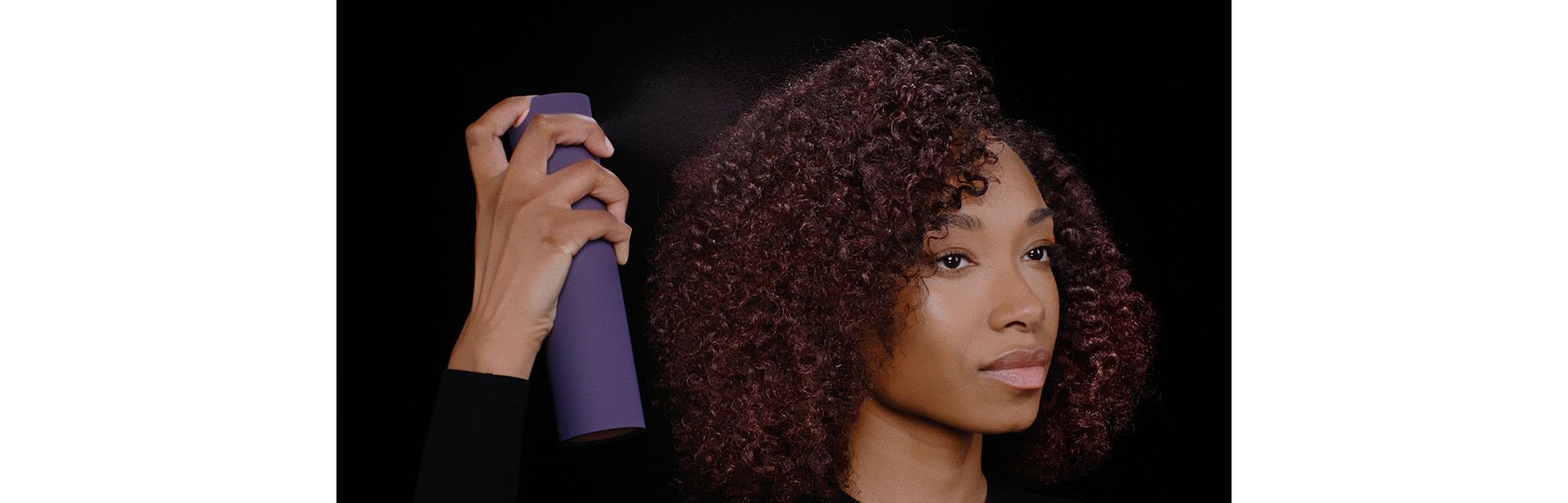 Model applies Dyson Chitosan Multi-use styling spray to her styled hair.