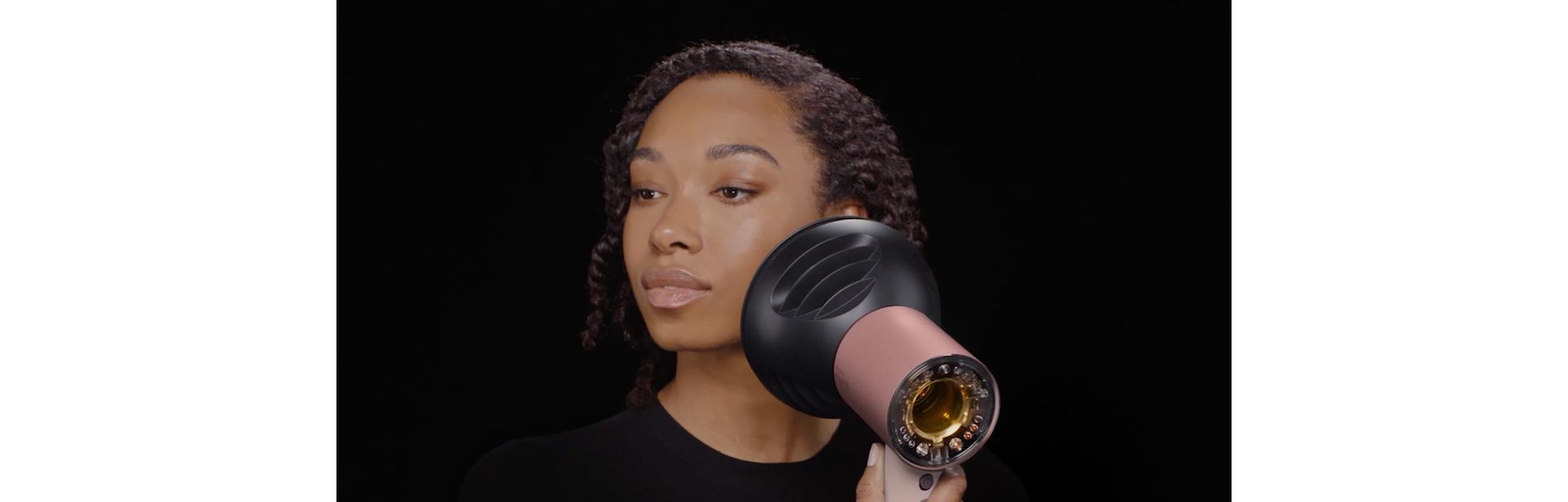 Model dries her hair with the Dyson Supersonic Nural hair dryer and diffuser.