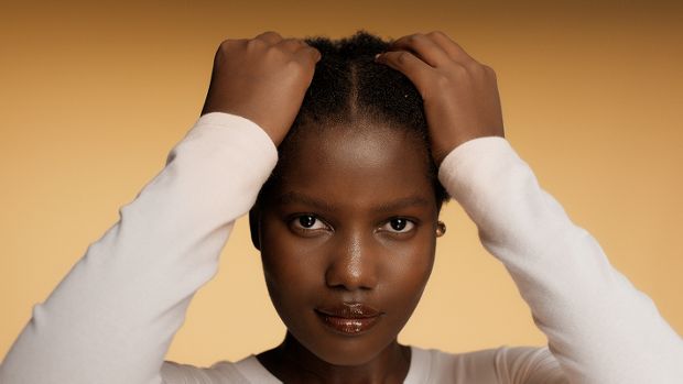 Model applies Dyson Amino Leave-in scalp bubble treatment to her scalp.