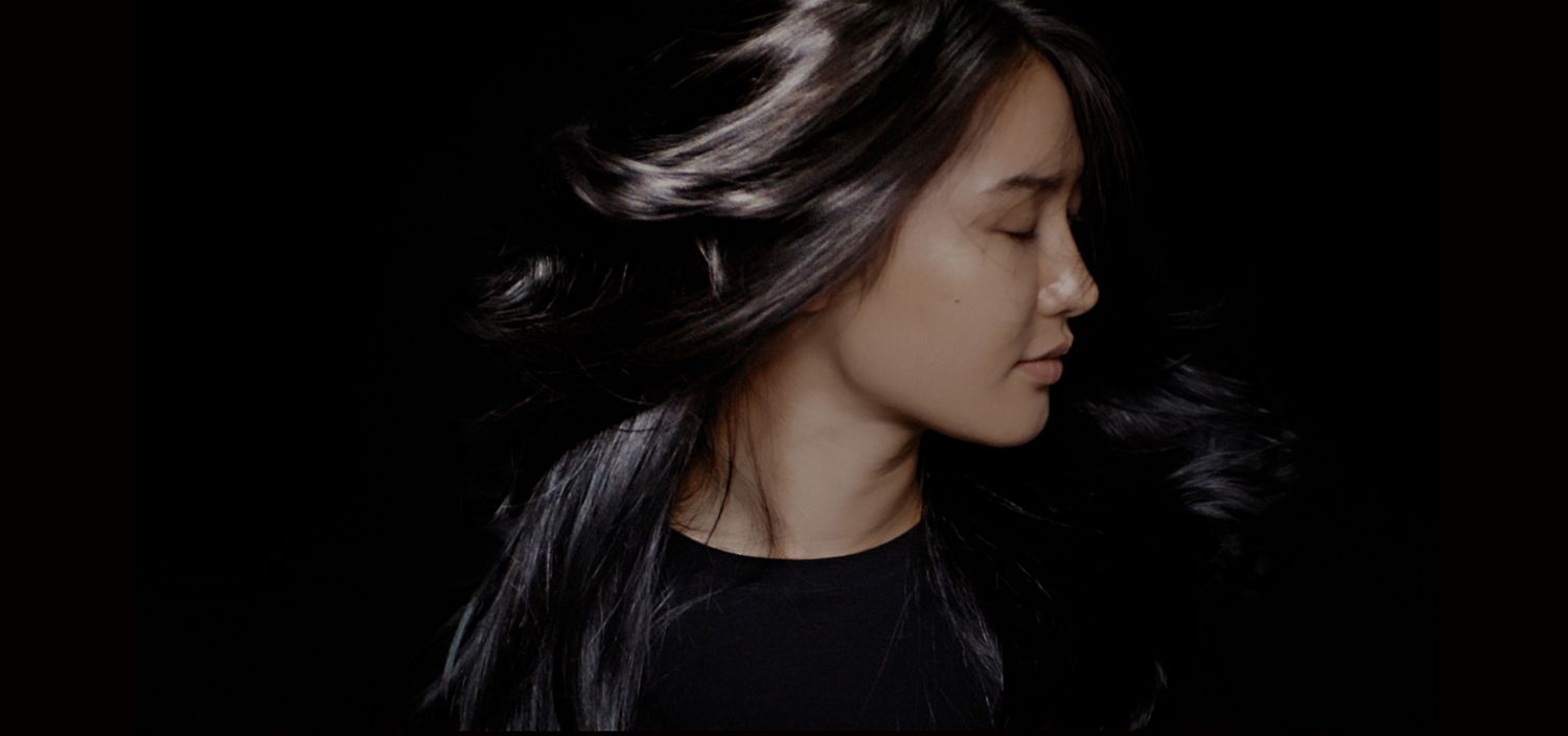 Model with coily hair after using the Dyson Chitosan Pre-style cream Straight to wavy rich conditioning