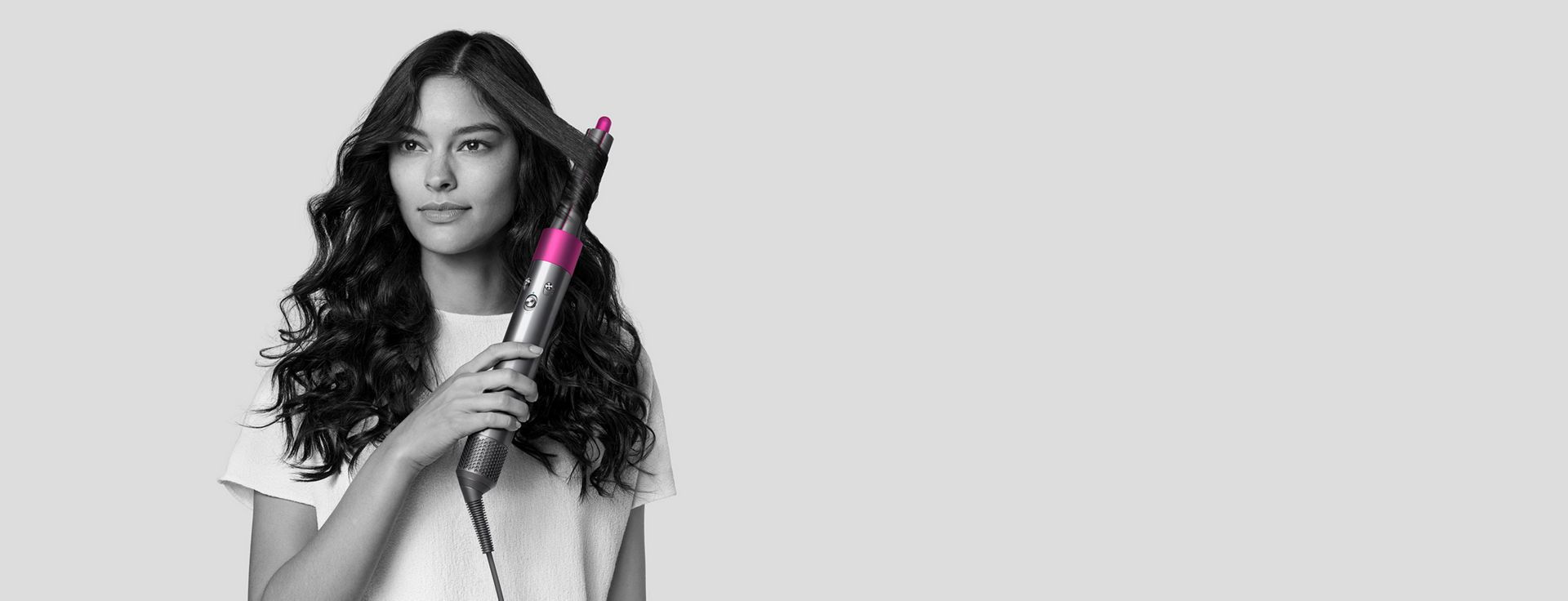 Woman styling hair with Dyson Airwrap styler.