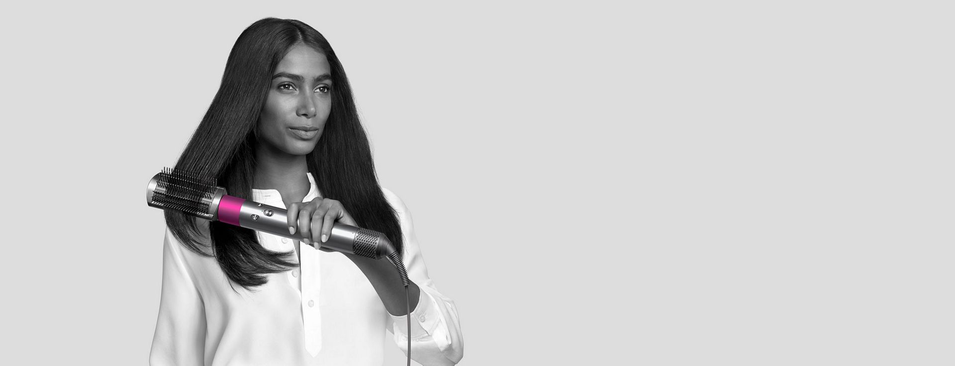 Woman styling hair with Dyson Airwrap styler.
