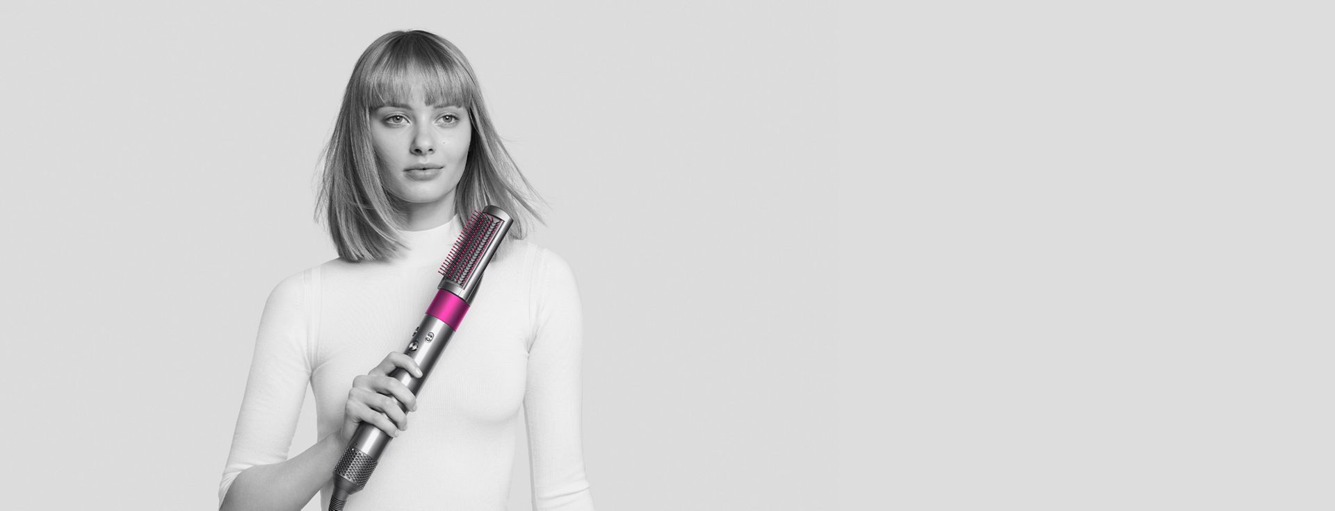 Woman styling hair with Dyson Airwrap styler.