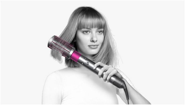 Model verwendet den Dyson Airwrap™, um krauses Haar zu glätten