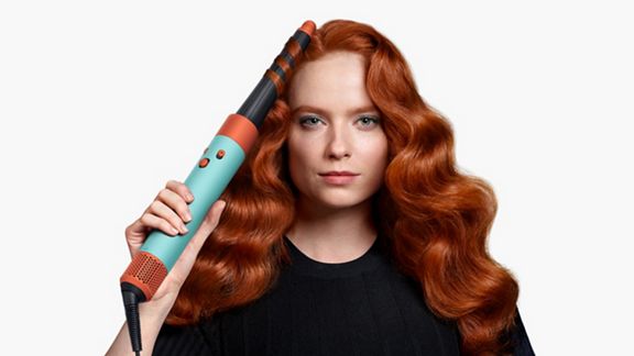 A model using the Ceramic Patina Dyson Airwrap i.d multi-styler and dryer to add waves to their hair.